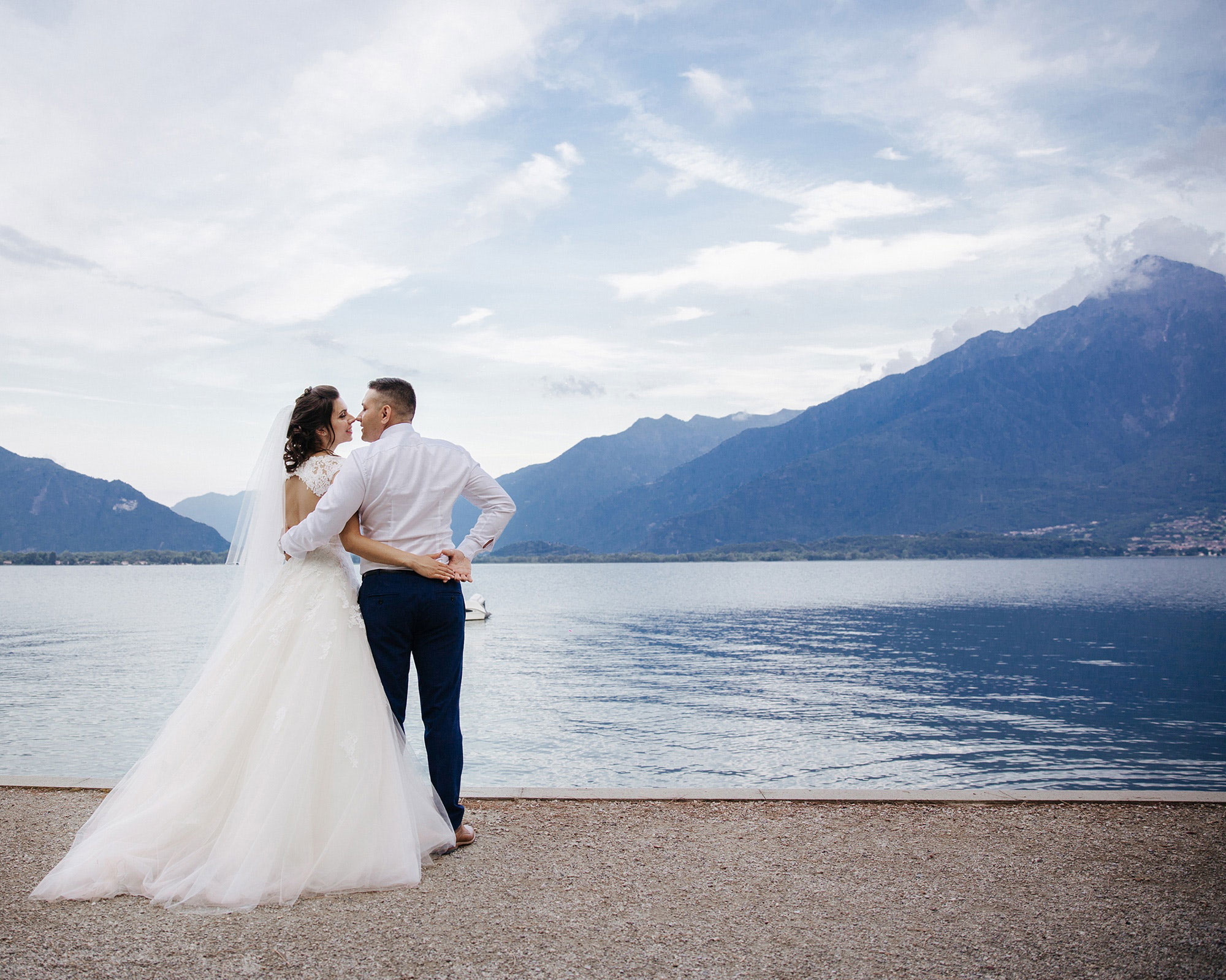 Bride and groom embracing by a lake